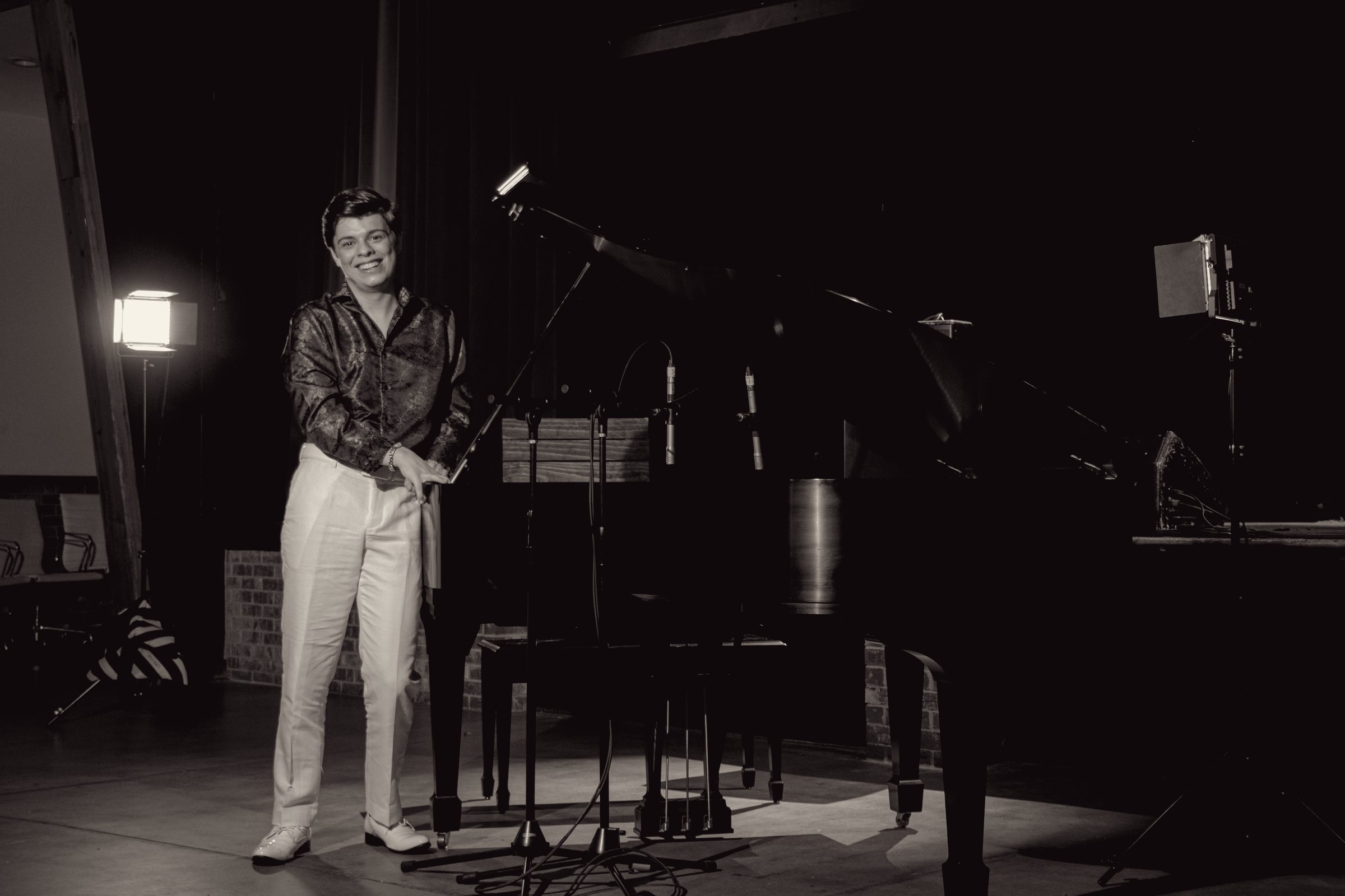 Michael Rainwater standing at the piano, smiling